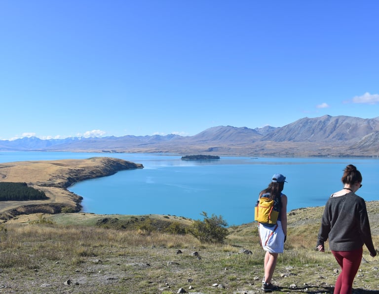 travellers walking by lake tekapo in south island of new zealand