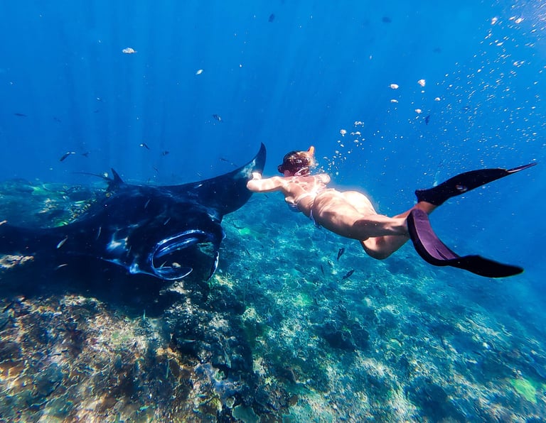 Ocean Calling Retreats, Rocío Ruiz swimming along a manta in Bali