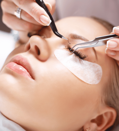 a woman getting her eyeliners done by a professional eyelashe