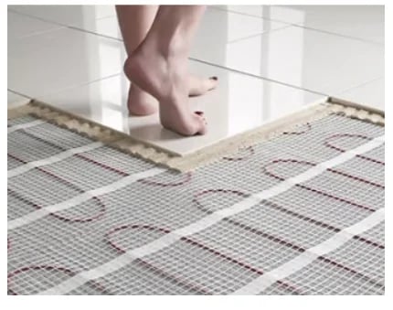 Sparky G ltd Electrician installing new underfloor matt on construction site of new build house