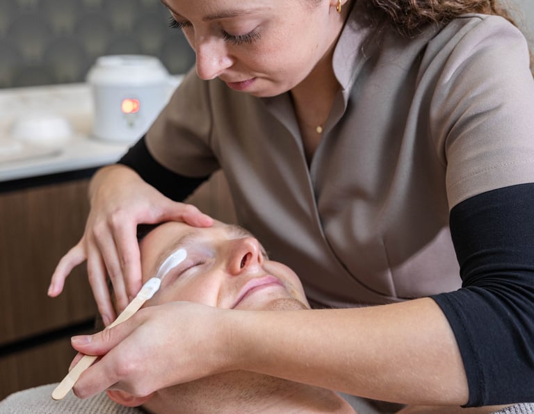 a man getting his eyebrows waxed at a salon