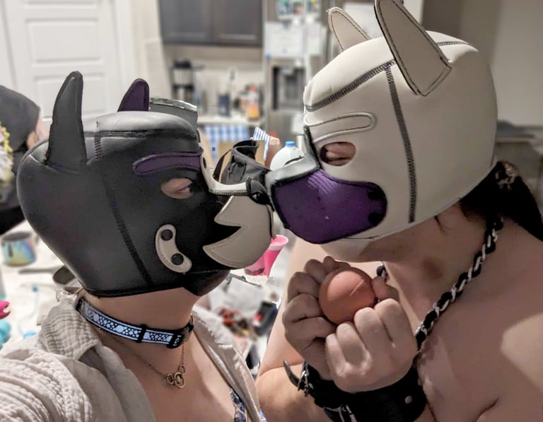 Two people in pup hoods rubbing snouts.