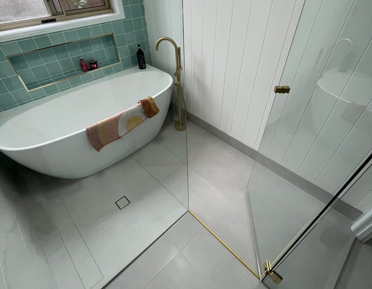 Frameless shower screen enclosure with brushed brass hardware