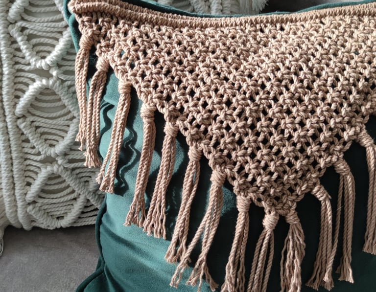 Išskirtinė rankų darbo interjero detalė - dekoratyvinė pagalvė su pintomis detalėmis.