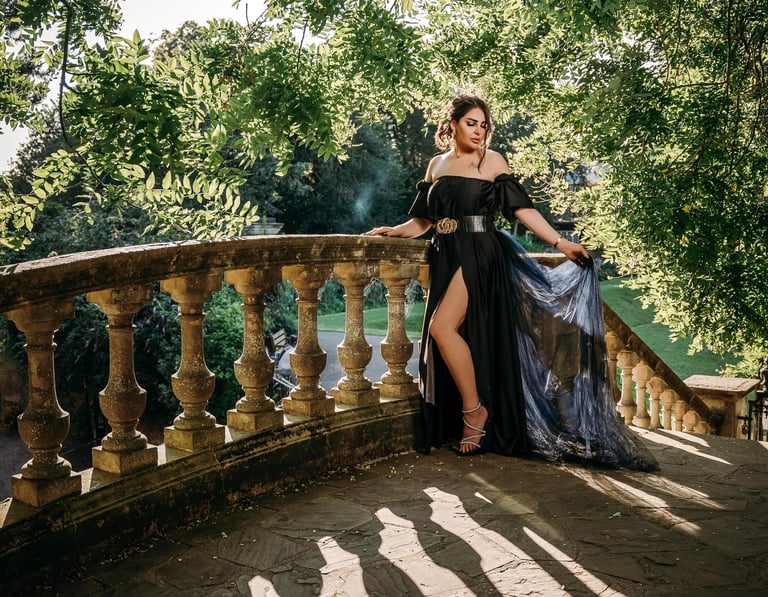 Model in black gown posing on stone stairs for a birthday photoshoot by Fred Art Studio.
