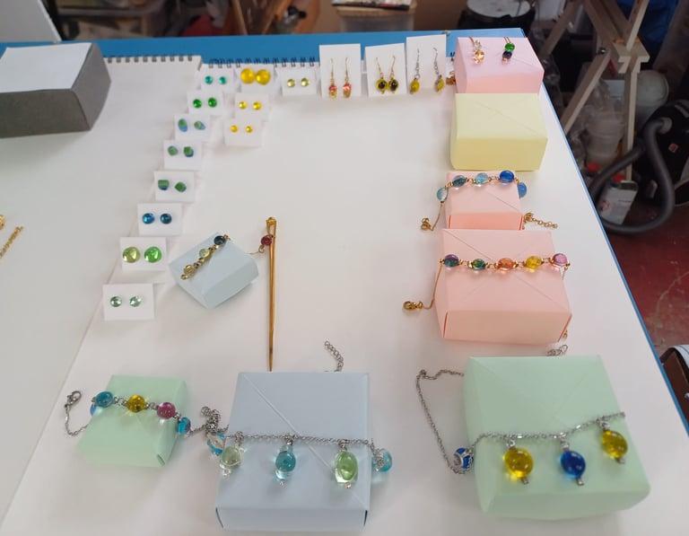 Sélection de bijoux artisanaux en verre et vitrail : bracelets et boucles d'oreilles colorés.
