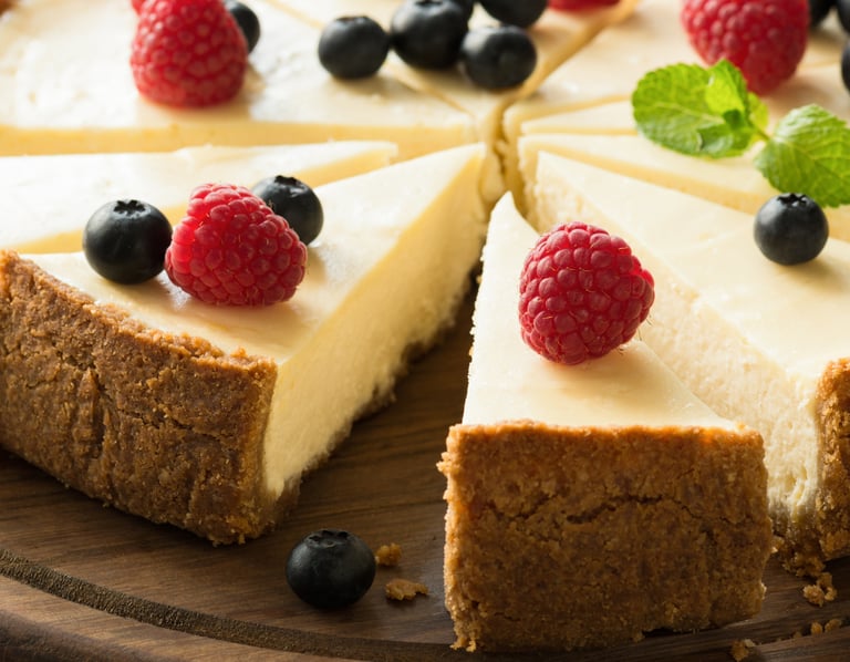 a cake with a slice of cheesecake on a wooden board