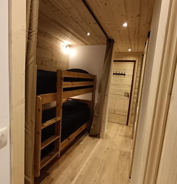 Mountain sleeping area with bunk beds and wooden interiors inside a practical Val Thorens ski-in ski-out apartment.