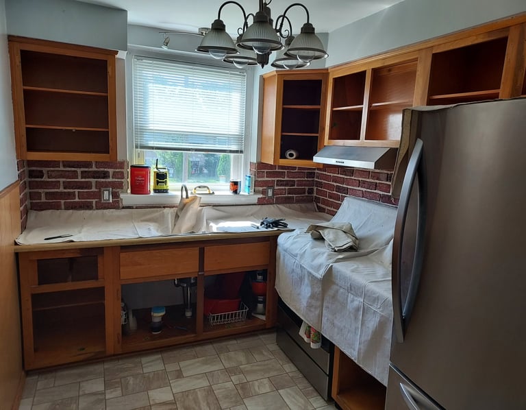 a kitchen with drop colthes on conter top
