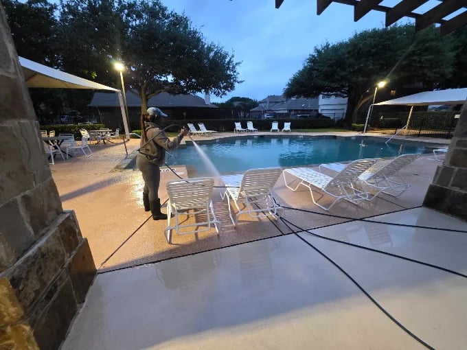 Actively pressure washing a pool deck