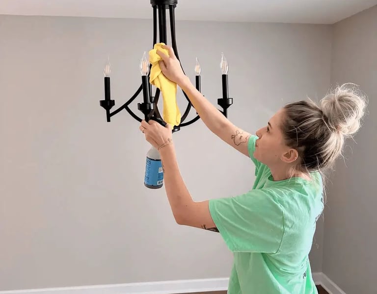 A professional cleaner carefully cleans a chandelier
