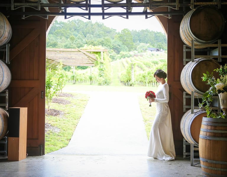 Mariage dans les vignes, mariée avec bouquet de roses rouges, décoration tonneaux