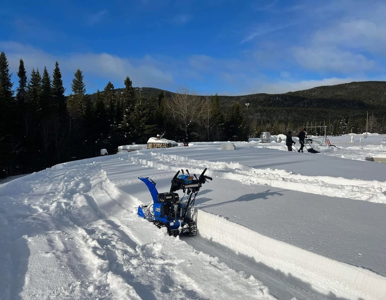 Flat Roof snow shoveling with people and a snowblower