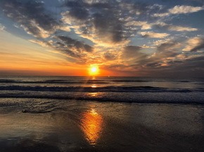 Fotografía del amanecer en  la playa de la Malvarrosa.
