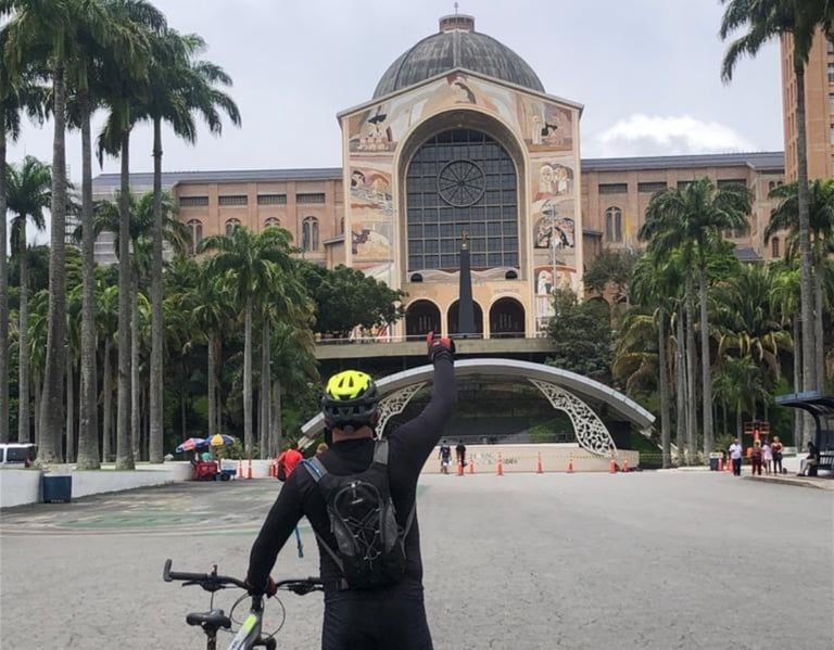 Ciclista de frente para a fachada do Santuário Nacional de Aparecida