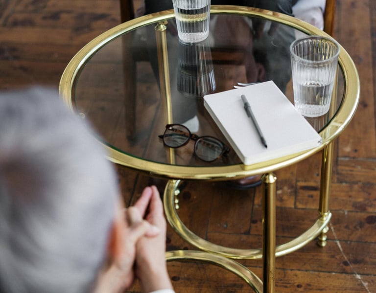 a man and woman sitting at a table with glasses
