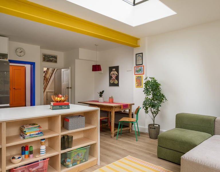 Dining table on side of kitchen with bench seating and colourful chairs
