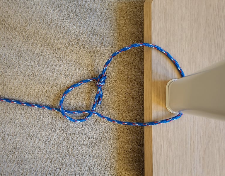 Running bowline knot tied around a vertical pole showing cinching action.