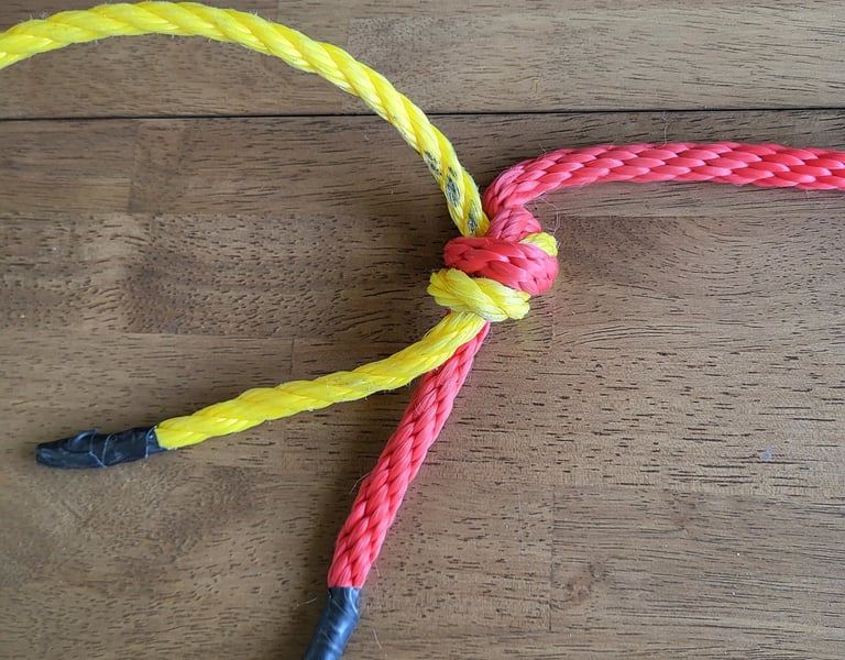 Flat overhand knot bend joining yellow poly line and red rope