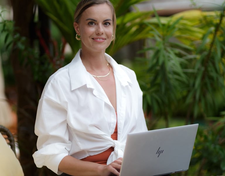 portrait of Eni. woman with a background of plants in nature working with a laptop