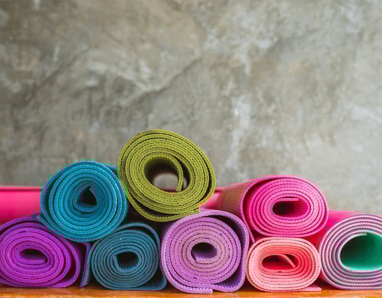 a stack of yoga mats with colorful colored yoga mats