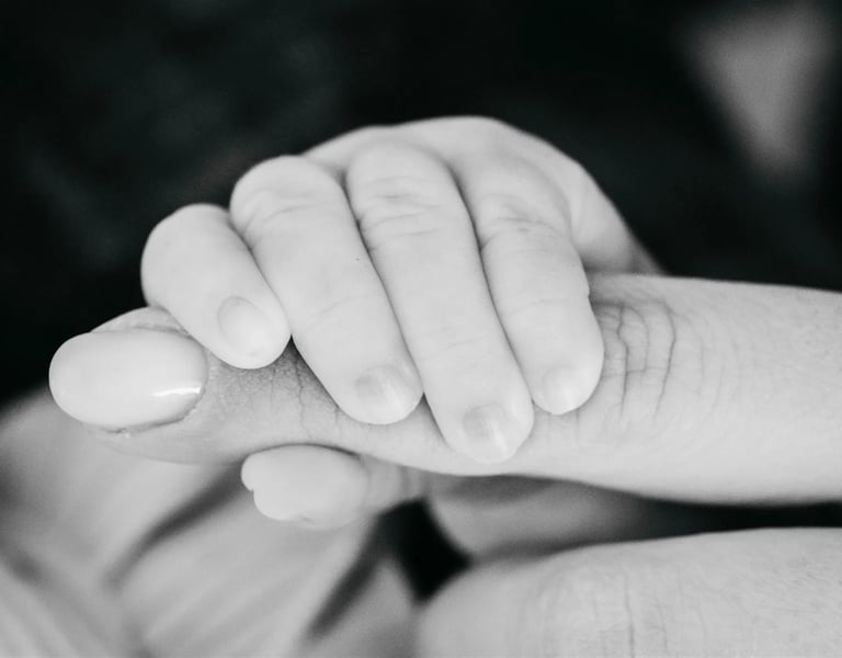 Main de bébé serrant le doigt de sa maman – photo de naissance en noir et blanc dans le Gard