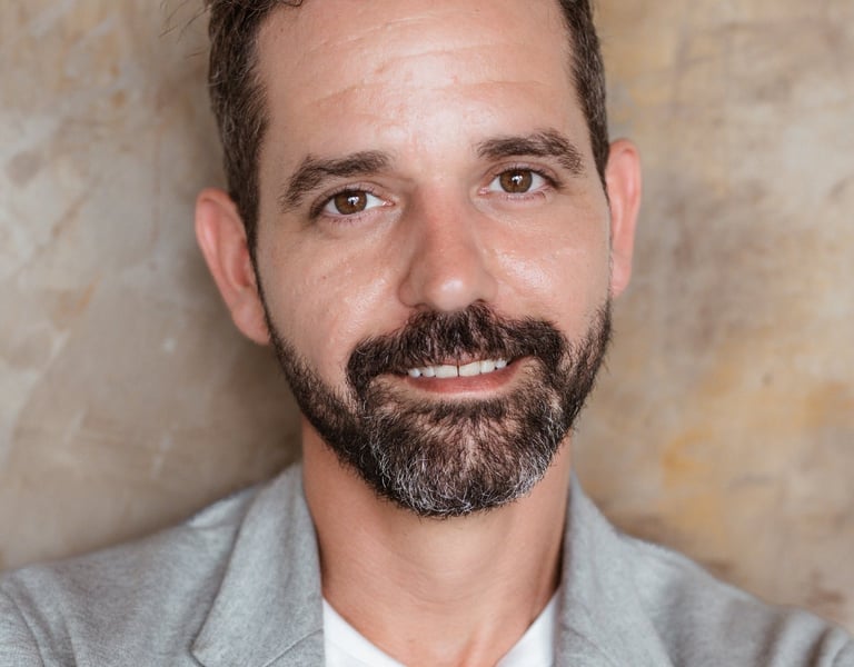 Michael Franco, HR strategist and workplace culture expert, wearing a white shirt and grey blazer in