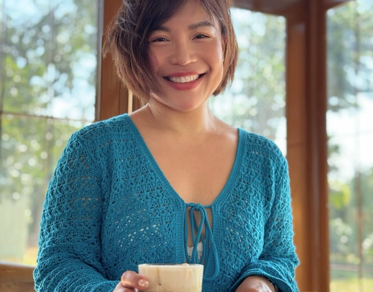 a woman in a blue sweater is smiling and holding a drink