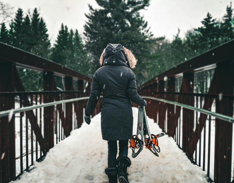 mujer cruzando un puente con nieve