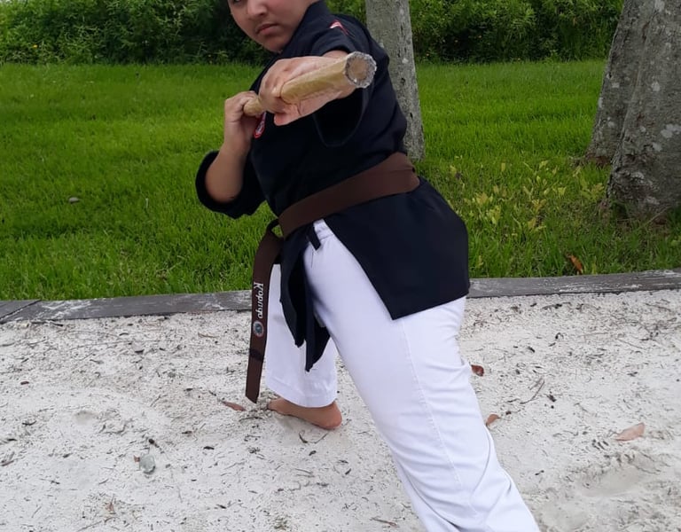 Kobudo practice with traditional Okinawan weapons in martial arts dojo.