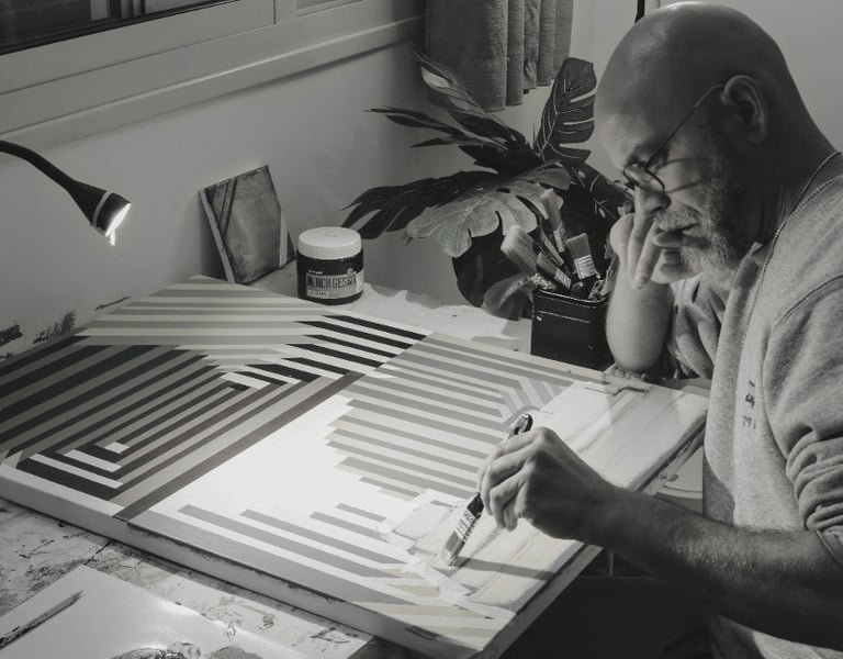 Artist Yonathan Niv working in his studio on abstract paintings and print layouts, surrounded by ori