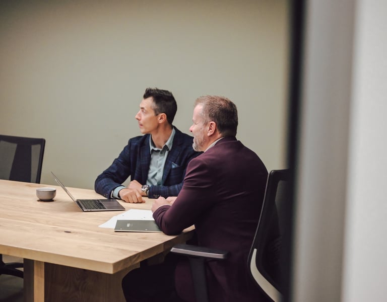 Men at a table discussing investment strategy