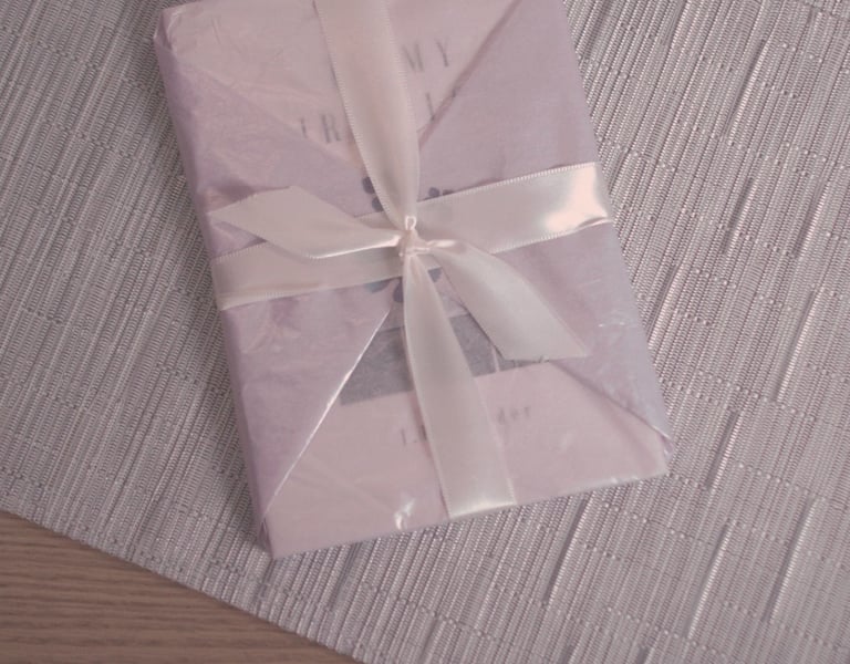 J.R. Sonder's book To My First Love (TMFL) wrapped in purple tissue wrap and a white ribbon.