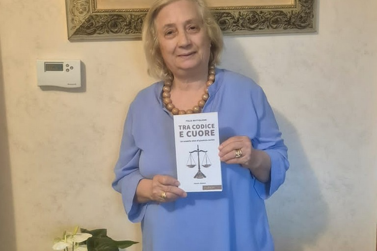 Italia Buttiglione segurando o seu livro: Tra codice e cuore