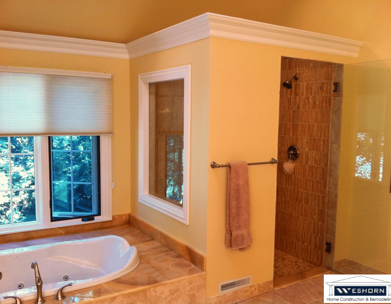 Master bathroom renovation featuring a walk-in tiled shower, jetted soaking tub, and custom crown molding.