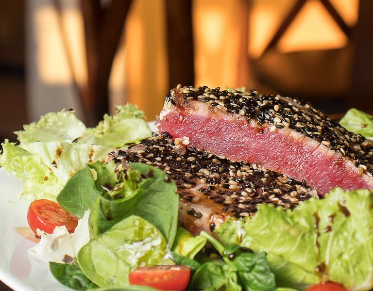 Fotografía de alimentos en Cancún. Medallón de atún sellado con ajonjolí y ensalada fresca.