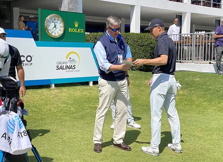 Casey handing Jordan Speith his scorecard.