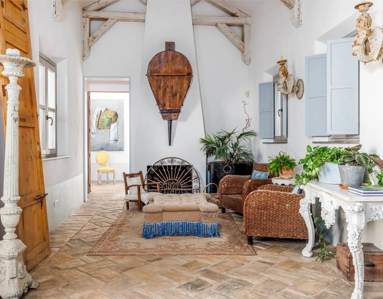 Rustic lounge with wicker chairs and fireplace at Finca Santa Katerina