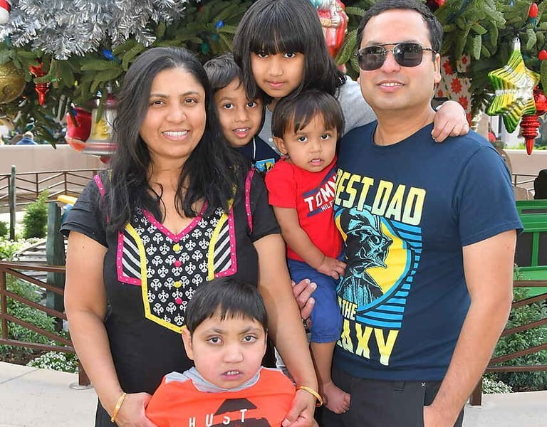 a family posing for a picture in front of a christmas tree