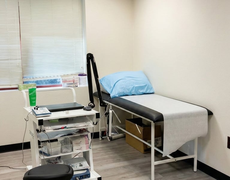 Neurology exam room with examination table and diagnostic equipment for neurological evaluations.