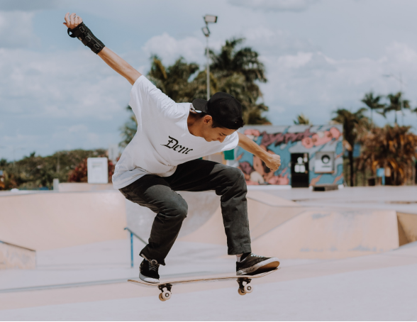 a man in a white shirt is doing a trick on a skateboard