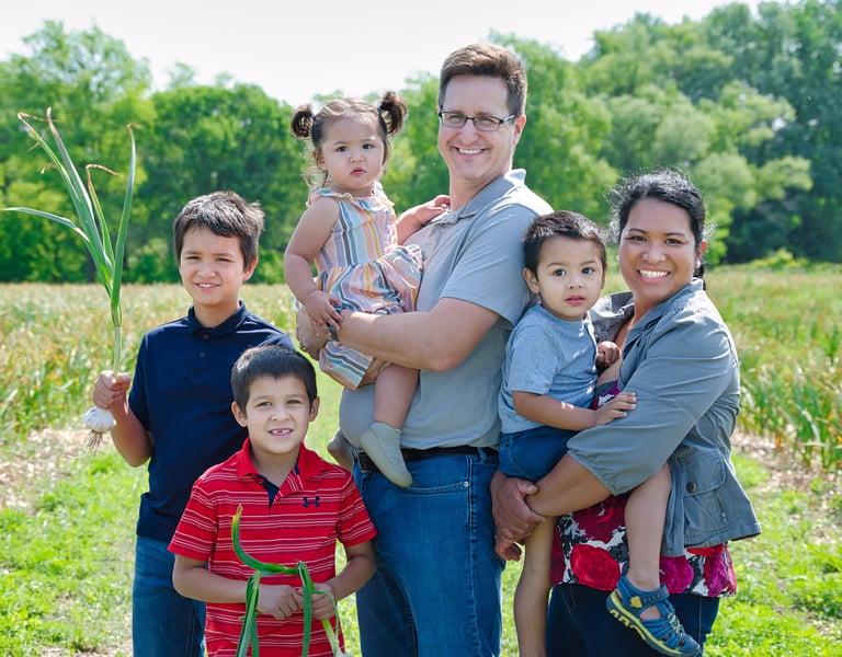 a family of four children posing for a photo in the garlic farm