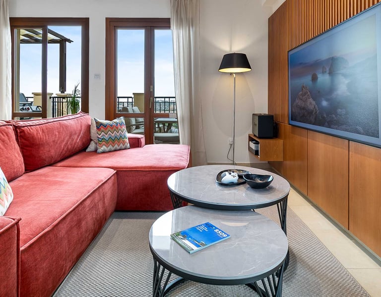 Living room seating area with large TV and sea view at Theseus Retreat holiday rental