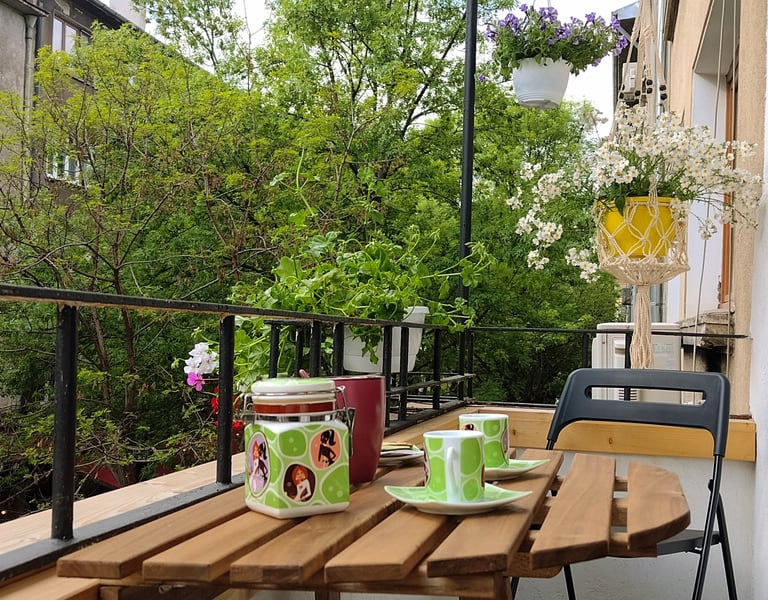 alt="Bijoux Apartment balcony with flowers and city view"