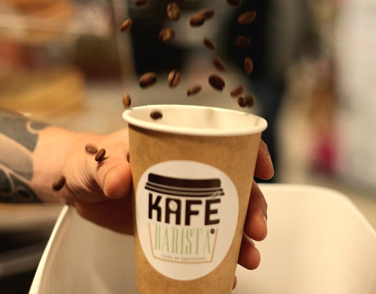 Présentation du café de spécialité Kafé Barista avec gobelet et grains de café