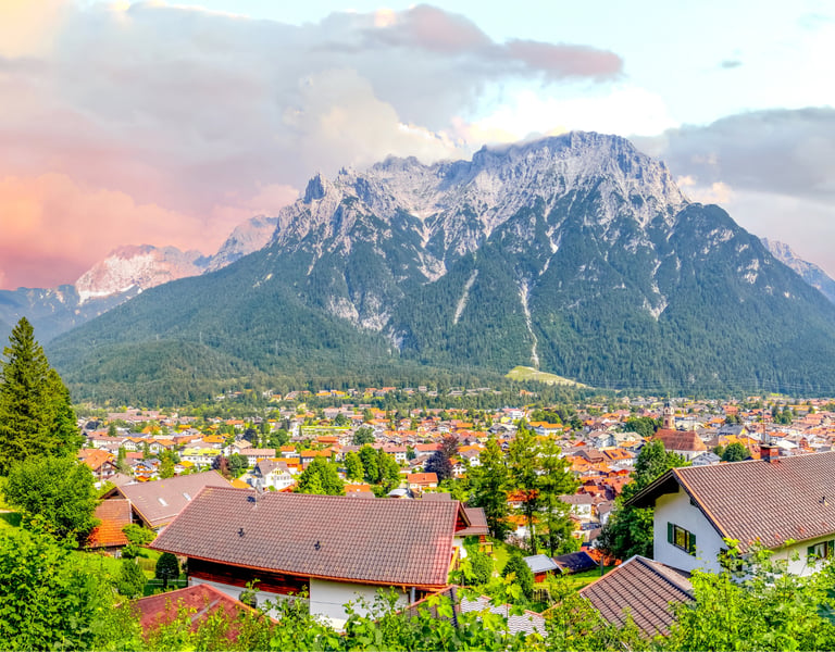Scenic landscape view of Mittenwald village nestled below the Karwendel mountains in the Bavarian Alps.