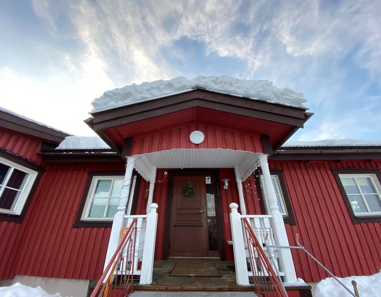 a red house with a red door and white stairs