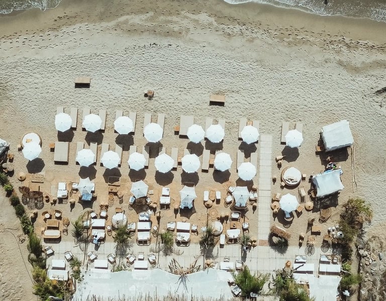 ue aérienne de la plage privée Playa Amor à Leucate, avec lits et transats face à la Méditerranée