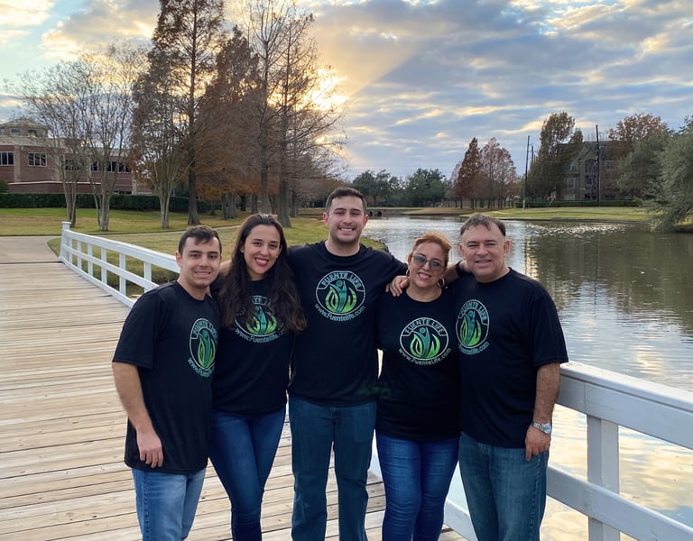 Fuente Life family founders standing together outdoors wearing branded shirts.