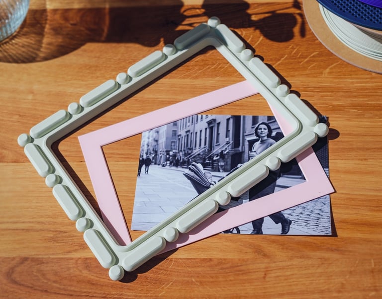 3D printed home decor photo and matboard being placed together, customizable frame design